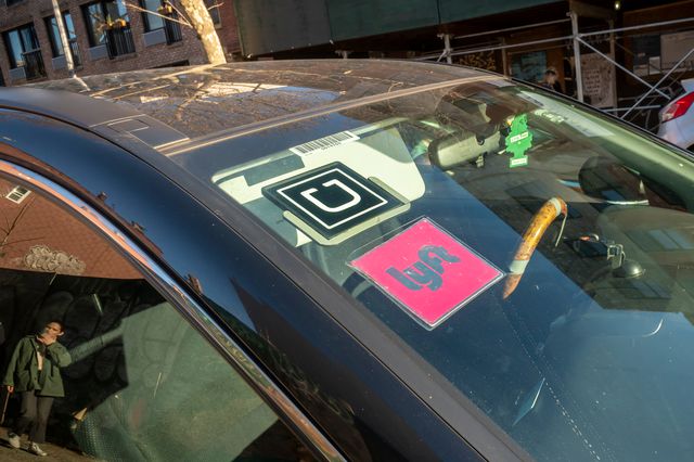 A windshield that shows both Uber and Lyft logos